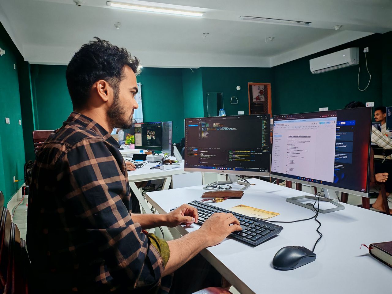 The Art of Drawing Readers In: Your attractive post title goes here A software developer working on code at a dual monitor setup in a modern office.